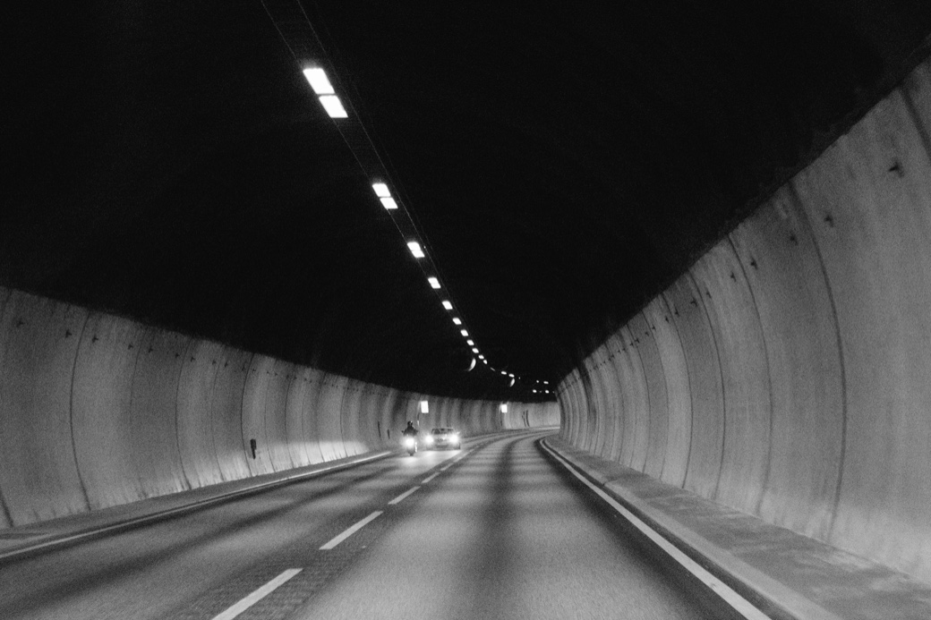 A car approaching through a curved Norwegian tunnel